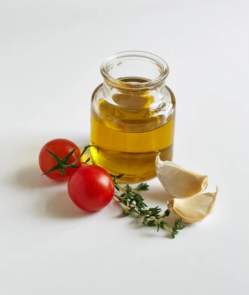 A jar of oil, garlic cloves, tomatoes — Stock Photo, Image
