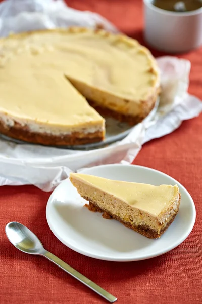 Un pastel de queso redondo en el fondo rojo — Foto de Stock