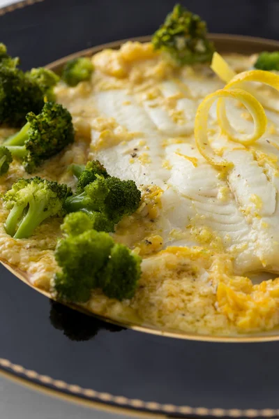 Prepared white fish fillet closeup with broccoli and lemon — Stock Photo, Image