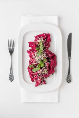 Beyaz plaka üzerinde kırmızı pancar soslu makarna