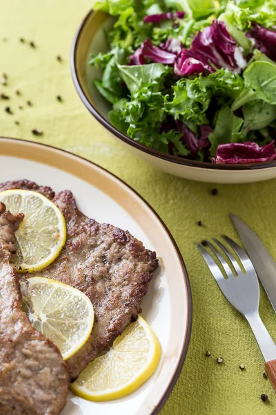 レモン スライスとグリーン サラダの準備された肉の部分 — ストック写真