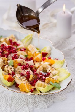 meyve ve sebze salatası soslu beyaz plaka üzerinde