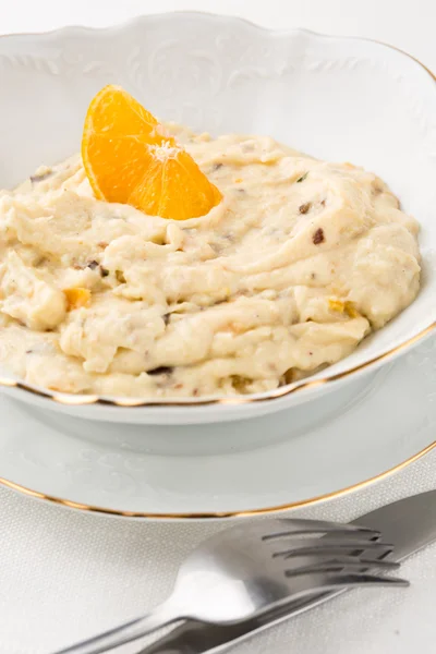 Oatmeal with dried fruits and orange in white bowl — Stock Photo, Image