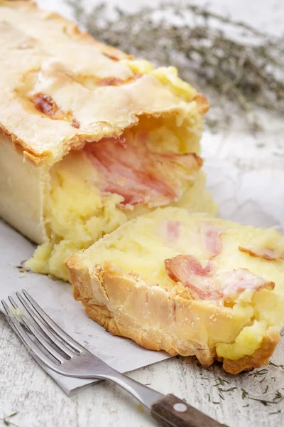 Potatoe pie with bacon on white wooden table — Stock Photo, Image