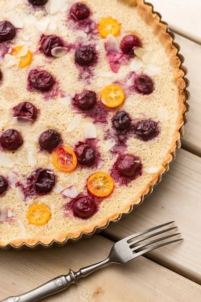 Baked tart with cherry and physalis slices in baking pan — Stock Photo, Image