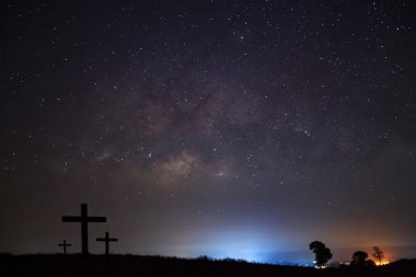 Silhouette of cross over milky way  clipart