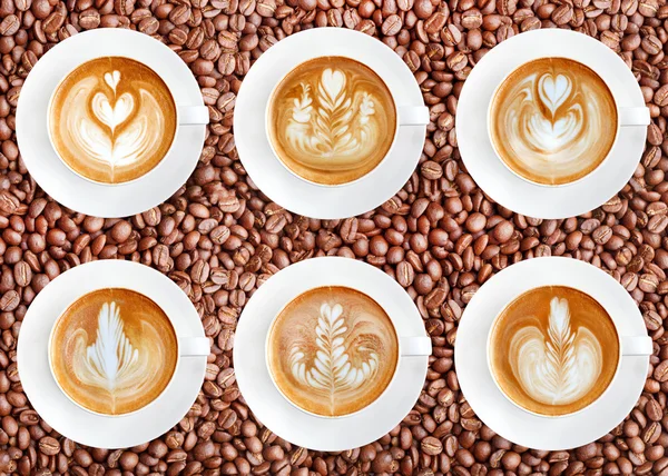 Latte art coffee on roasted coffee beans background — Stock Photo, Image