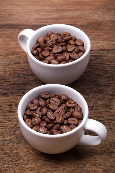 Cup of coffee beans on the brown wooden background — Stock Photo, Image