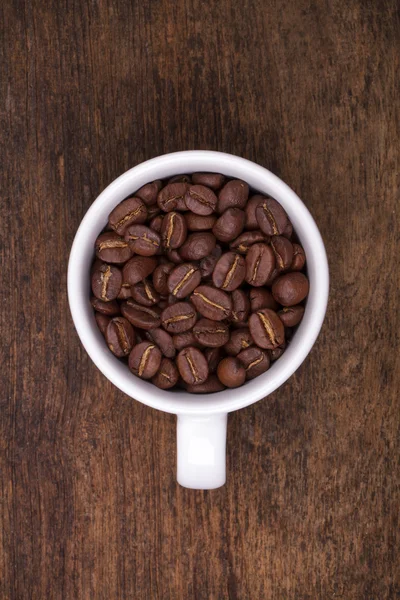 Cup of coffee beans on the brown wooden background — Stock Photo, Image