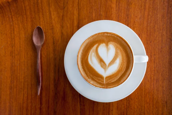 Kopje koffie latte en lepel op houten — Stockfoto