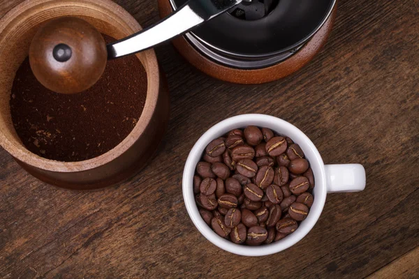 Чашка кофе фасоль на коричневой деревянной заросли — стоковое фото
