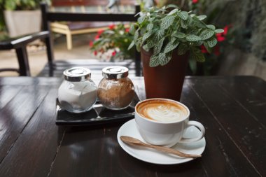 Latte üzerinde ahşap masa kahve bir fincan