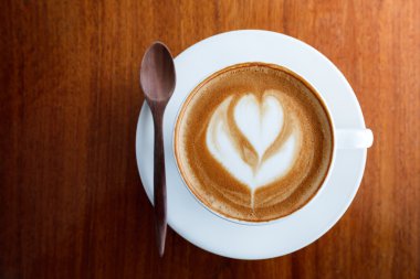 Fincan sütlü kahve ve tahta kaşık