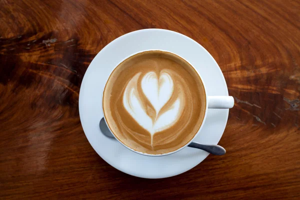 Kopje koffie latte en lepel op houten — Stockfoto