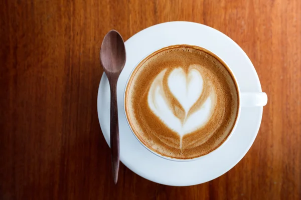 Kopje koffie latte en lepel op houten — Stockfoto