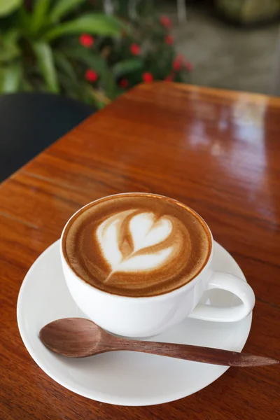 Xícara de café com leite e colher em madeira — Fotografia de Stock