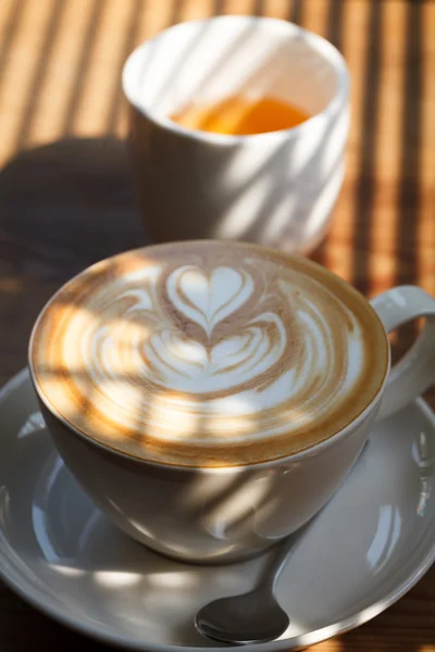 Kopje latte koffie en thee met morring licht — Stockfoto