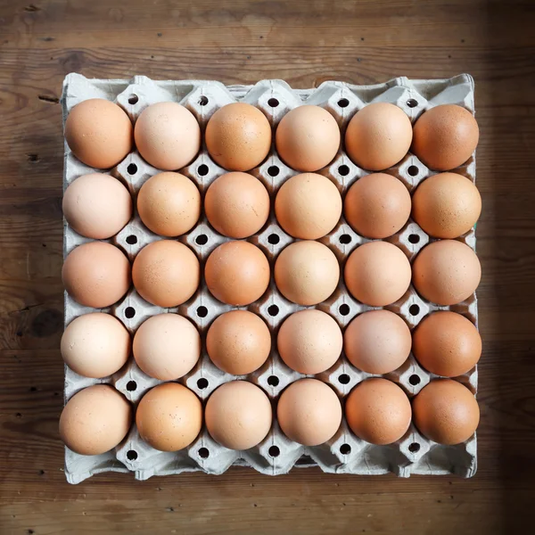 Eieren in de papierlade op houten tafel — Stockfoto