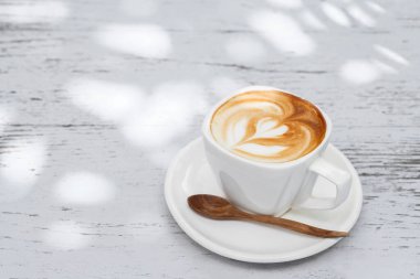 Latte üzerinde beyaz ahşap tabl kahve fincan