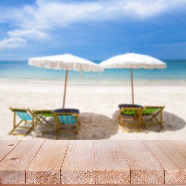 Ahşap masa üstü bulanık mavi denizi ve beyaz kum plaj