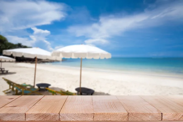 Wood table top on blurred blue sea and white sand beach background — Stock Photo, Image