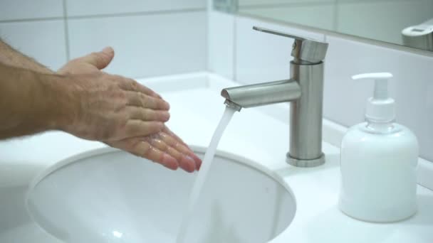 Förebyggande av Coronavirus. En man tvättar händerna noggrant med tvål och varmt vatten hemma. — Stockvideo
