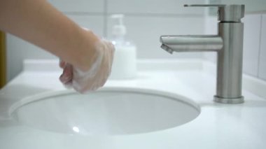 Coronavirus önleme. Bir kadın ellerini sabun ve sıcak suyla iyice yıkıyor..
