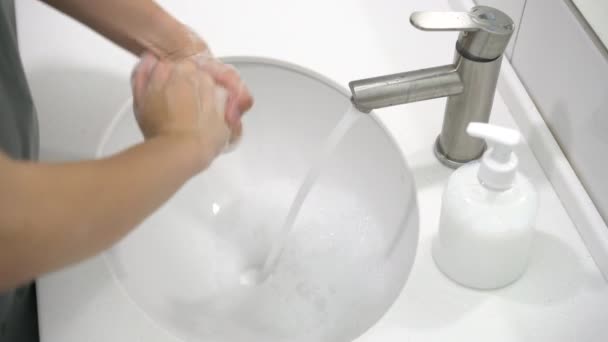Zapobieganie koronawirusom. Kobiety dokładnie myją mu ręce mydłem i ciepłą wodą w domu.. — Wideo stockowe