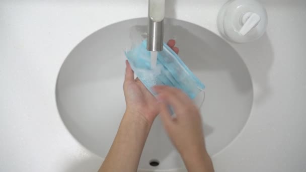 Le mani femminili lavano la maschera monouso con sapone per il riutilizzo a causa di problemi finanziari. — Video Stock