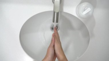 Coronavirus önleme. Bir kadın ellerini sabun ve sıcak suyla iyice yıkıyor..