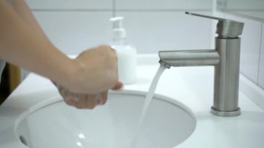 Coronavirus önleme. Bir kadın ellerini sabun ve sıcak suyla iyice yıkıyor..