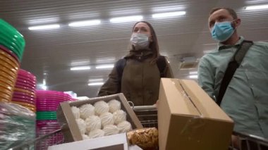 Tıbbi maske takan çift boş bir süpermarkete ya da markete girip yiyecek alıyor.. 