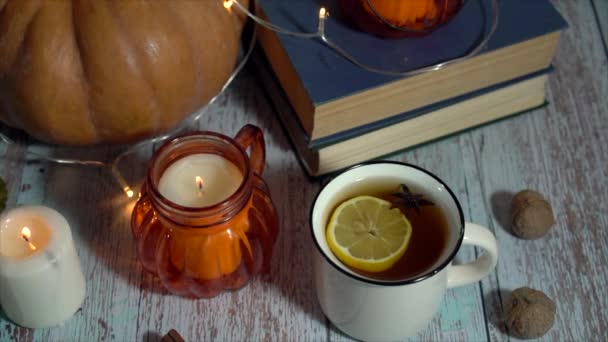 Fondo de Acción de Gracias, composición con calabazas, taza de té caliente con limón, velas sobre fondo de madera. — Vídeos de Stock