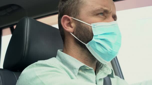 Homem adulto dirigindo carro usando máscara protetora durante a epidemia de coronavírus. — Vídeo de Stock