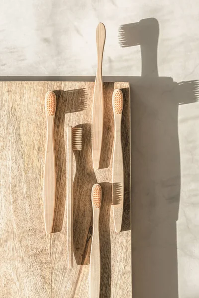 Composición con cepillos de dientes de bambú biodegradables sobre fondo de madera. — Foto de Stock