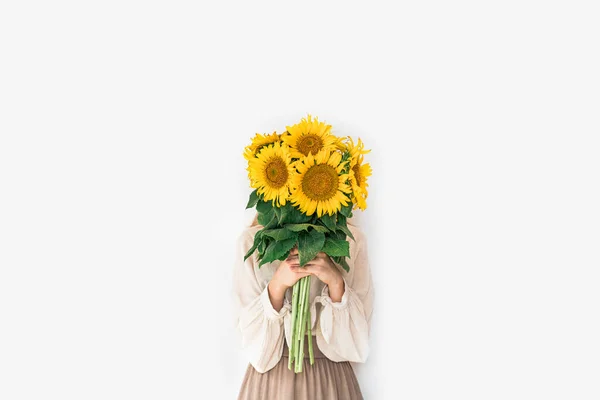 Hermosa joven en vestido de lino con flores de girasol ramo. Imagen De Stock