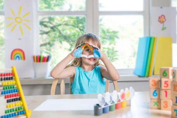 Engraçado bonito menino feliz mostra as mãos sujas com tinta. — Fotografia de Stock