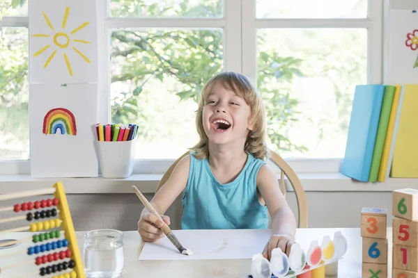 Divertido hermoso niño feliz dibuja riendo con pintura. Imágenes De Stock Sin Royalties Gratis