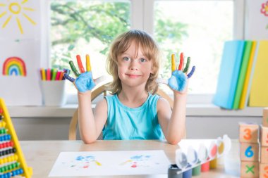 Komik çocuk ellerini boyayla kirletiyor..