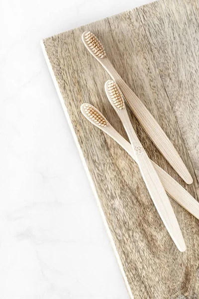 Composition with biodegradable bamboo toothbrushes on wooden background. — Stock Photo, Image