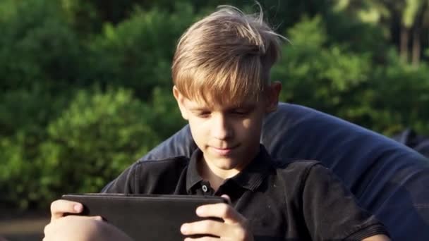 Tiener chatten op tablet bij zonsondergang 4k — Stockvideo