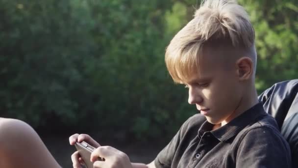 Tonåring chattar på tabletten vid solnedgången 4k — Stockvideo