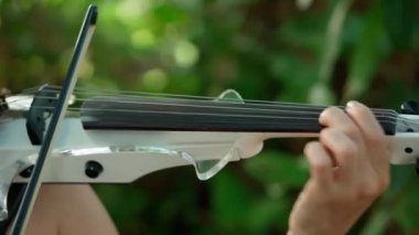 Genç kız keman çalıyor. Yakın çekim.