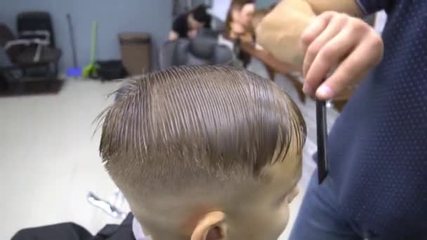 Menino no barbeiro em um corte de cabelo — Vídeo de Stock