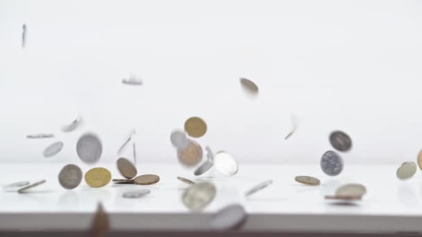 Las monedas están cayendo sobre la mesa. Detener movimiento — Vídeos de Stock