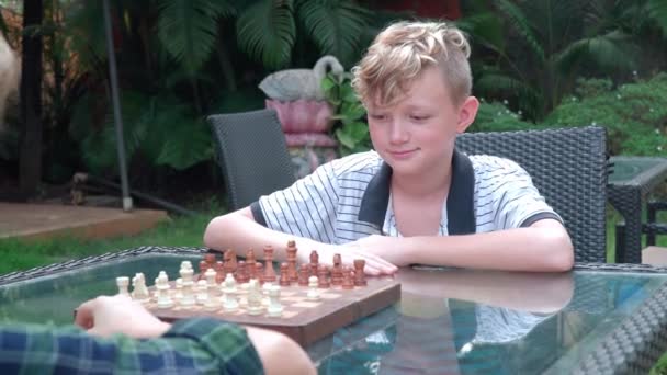 Junge gewinnt Freund im Schach — Stockvideo