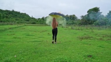 Kadın şemsiyeyle yürüyor.