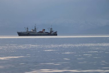 Arkasında dağlar olan sanayi gemisi.