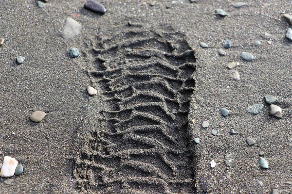 Boot footprint on wet sand. Stock Photo