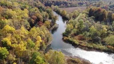 Tunkhannock, Pennsylvania, ABD yakınlarındaki nehir kenarındaki sonbahar yeşilliklerinin çarpıcı renklerinin hava görüntüsü.